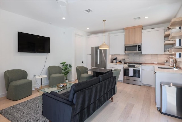 87 Chalmers Ave, Austin, TX 78702 - kitchen with appliances with stainless steel finishes, open shelves, light countertops, backsplash, and white cabinetry