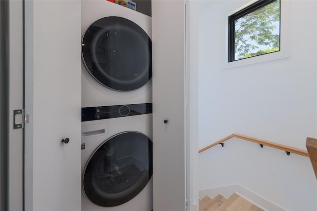 87 Chalmers Ave, Austin, TX 78702 - washroom featuring stacked washer / dryer and wood finished floors
