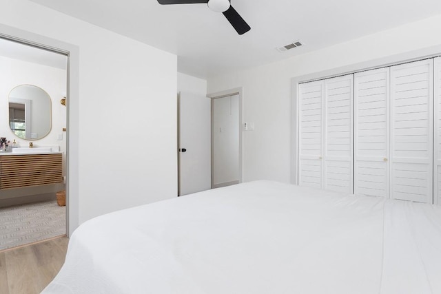 1001 E Applegate Dr, Austin, TX 78753 - bedroom featuring wood finished floors, a closet, ensuite bath, and a ceiling fan