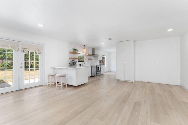 1001 E Applegate Dr, Austin, TX 78753 - kitchen with open shelves, french doors, light wood-style flooring, light countertops, and a peninsula