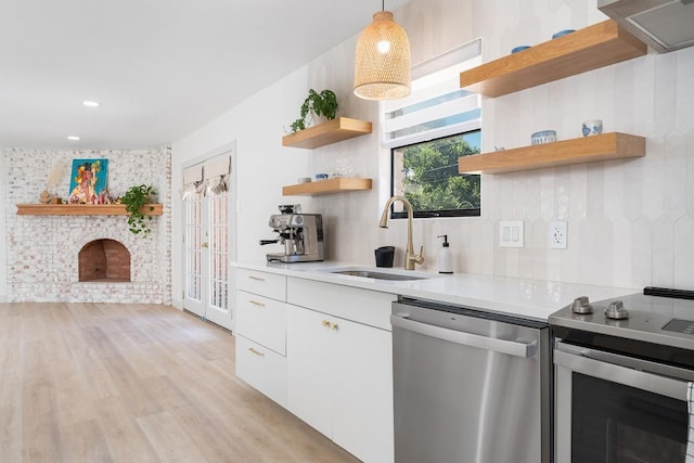 1001 E Applegate Dr, Austin, TX 78753 - kitchen featuring appliances with stainless steel finishes, open shelves, light countertops, white cabinets, and light wood finished floors