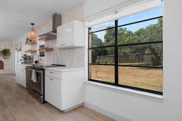 1001 E Applegate Dr, Austin, TX 78753 - kitchen with stainless steel range with electric stovetop, wall chimney range hood, open shelves, light wood finished floors, and light countertops