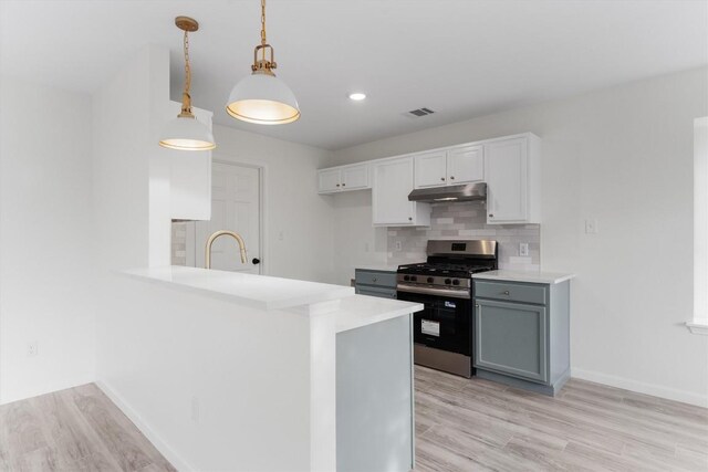 15532 Emmaleighs Ln, Pflugerville, TX 78660 - kitchen with stainless steel range with gas cooktop, under cabinet range hood, light countertops, light wood-type flooring, and backsplash