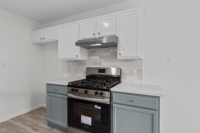 15532 Emmaleighs Ln, Pflugerville, TX 78660 - kitchen with stainless steel gas range, under cabinet range hood, light wood-style flooring, decorative backsplash, and light countertops