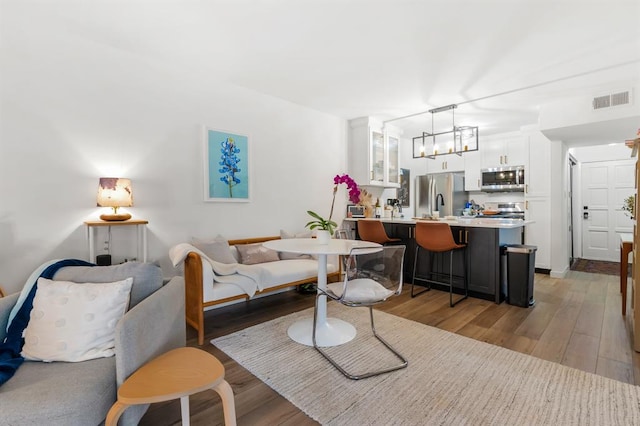 3431 N Hills Dr Unit 112, Austin, TX 78731 - living area with light wood-style flooring and a chandelier
