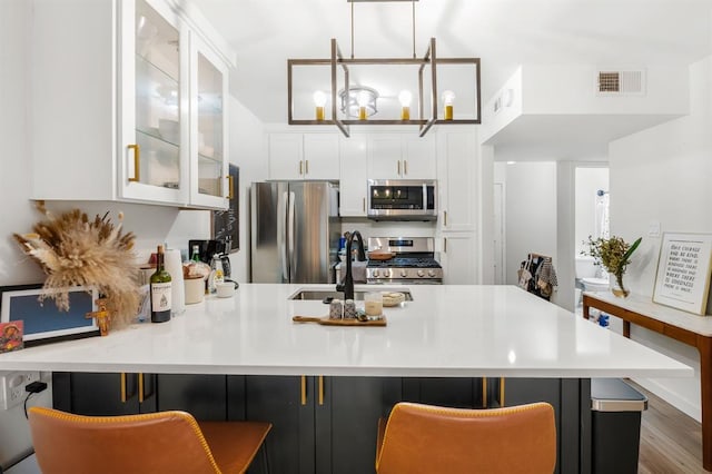 3431 N Hills Dr Unit 112, Austin, TX 78731 - kitchen featuring stainless steel appliances, glass insert cabinets, a peninsula, white cabinets, and light countertops