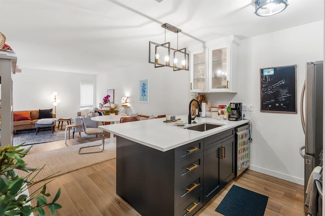 3431 N Hills Dr Unit 112, Austin, TX 78731 - kitchen with freestanding refrigerator, white cabinets, light countertops, glass insert cabinets, and a peninsula