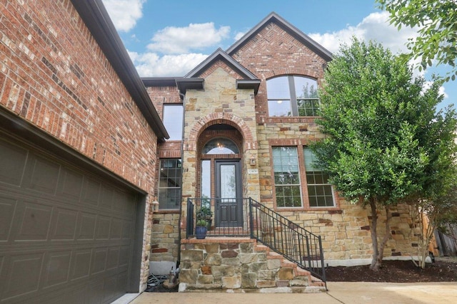 12404 Calistoga Way, Austin, TX 78732 - view of front of property with stone siding, a garage, brick siding, and driveway
