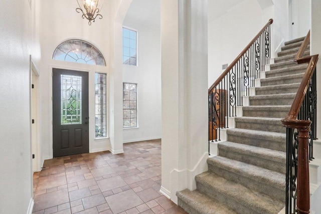 12404 Calistoga Way, Austin, TX 78732 - entryway featuring arched walkways, stairway, a towering ceiling, and stone finish flooring