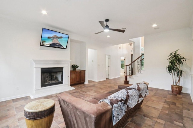 12404 Calistoga Way, Austin, TX 78732 - living area with ceiling fan, stairs, a fireplace with raised hearth, recessed lighting, and ornamental molding