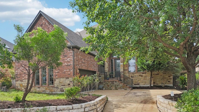 12404 Calistoga Way, Austin, TX 78732 - view of front of home featuring brick siding, concrete driveway, roof with shingles, stone siding, and a garage