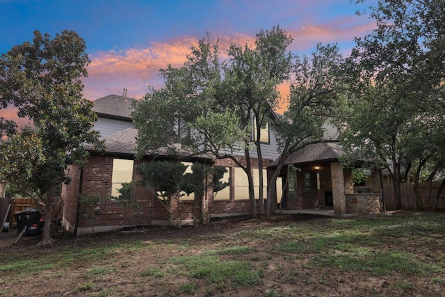 12404 Calistoga Way, Austin, TX 78732 - back of property at dusk featuring brick siding and a shingled roof