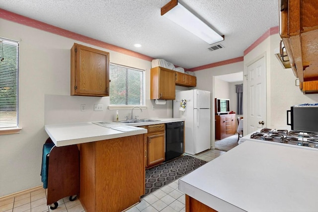 12062 Lincolnshire Dr, Austin, TX 78758 - kitchen featuring black dishwasher, freestanding refrigerator, a textured ceiling, light countertops, and brown cabinetry