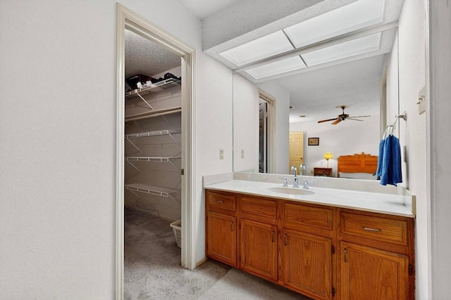 12062 Lincolnshire Dr, Austin, TX 78758 - ensuite bathroom featuring vanity, a walk in closet, and ceiling fan