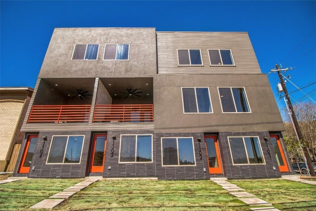 700 Denson Dr Unit 1104, Austin, TX 78752 - view of front of home with a balcony, a ceiling fan, a front lawn, and stucco siding