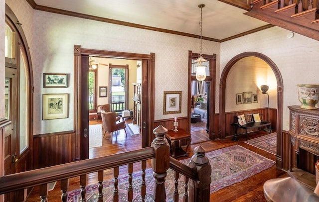 624 Saint Louis St, Gonzales, TX 78629 - hall featuring wood-type flooring, wainscoting, wallpapered walls, crown molding, and arched walkways