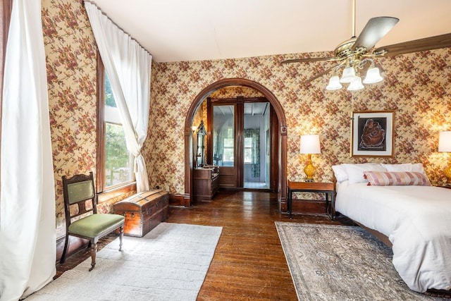 624 Saint Louis St, Gonzales, TX 78629 - bedroom with wallpapered walls, arched walkways, wood finished floors, and a ceiling fan