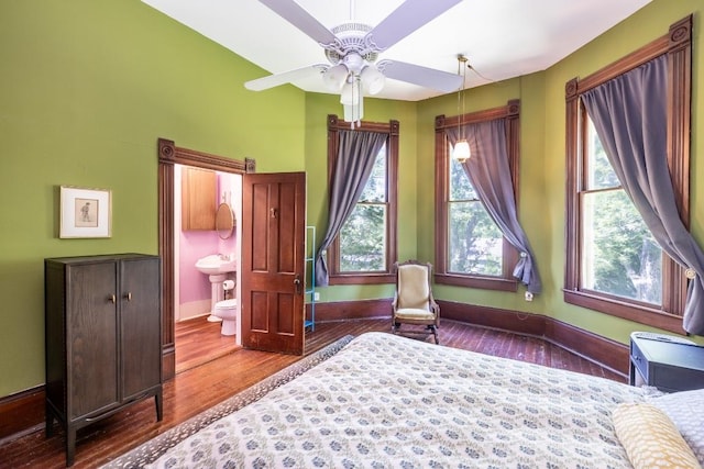 624 Saint Louis St, Gonzales, TX 78629 - bedroom featuring wood finished floors, multiple windows, and connected bathroom