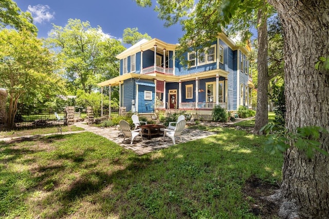624 Saint Louis St, Gonzales, TX 78629 - back of property with a balcony, a fire pit, and a patio