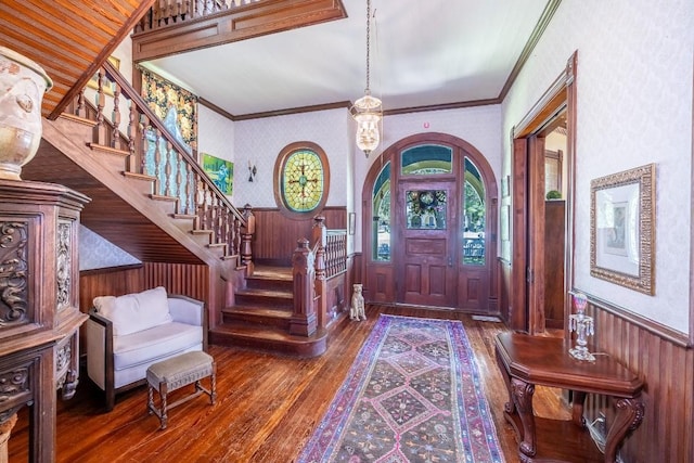 624 Saint Louis St, Gonzales, TX 78629 - entrance foyer featuring wood-type flooring, a wainscoted wall, stairs, wallpapered walls, and crown molding