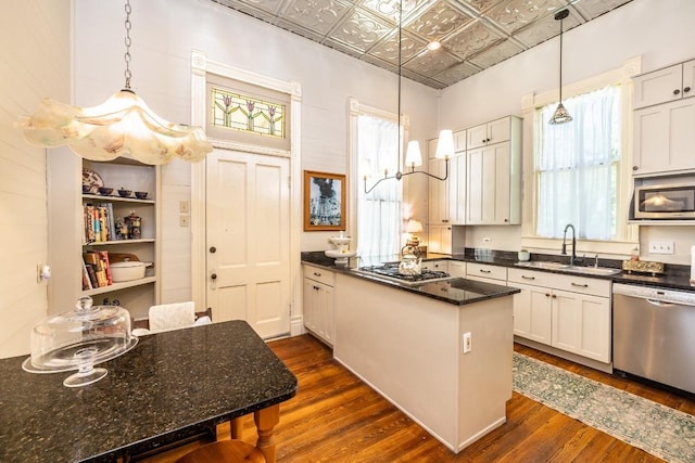 624 Saint Louis St, Gonzales, TX 78629 - kitchen with appliances with stainless steel finishes, an ornate ceiling, dark wood-type flooring, a peninsula, and healthy amount of natural light