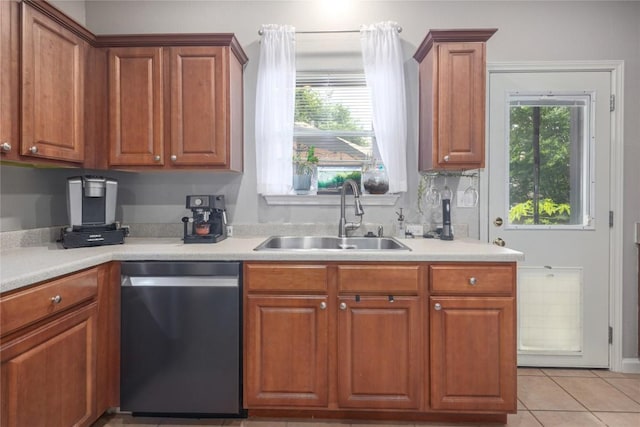 9213 Brents Elm Dr, Austin, TX 78744 - kitchen featuring dishwashing machine, light countertops, brown cabinetry, and light tile patterned floors