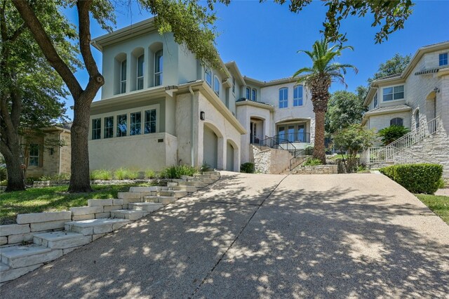 4332 Canoas Dr, Austin, TX 78730 - view of front facade featuring stairway, stucco siding, driveway, and a garage