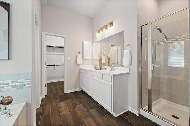 2205 Bonavista Way, Leander, TX 78641 - full bathroom featuring a shower stall, wood finish floors, a spacious closet, a bath, and double vanity