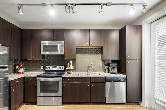 1900 Barton Springs Rd Unit 5033, Austin, TX 78704 - kitchen with stainless steel appliances, light wood finished floors, backsplash, and dark brown cabinetry
