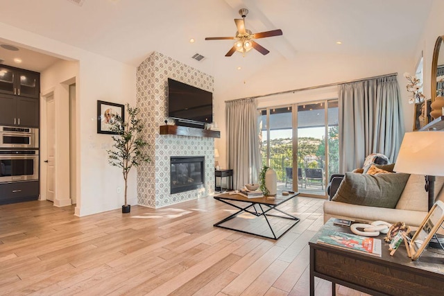 4106 Paleleaf Path, Bee Cave, TX 78738 - living room featuring a ceiling fan, light wood-style floors, beam ceiling, a tile fireplace, and high vaulted ceiling