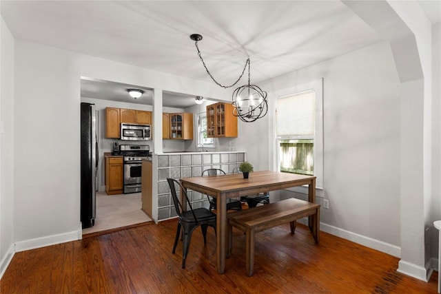 1208 Cedar Ave, Austin, TX 78702 - dining room with a chandelier, wood finished floors, and arched walkways