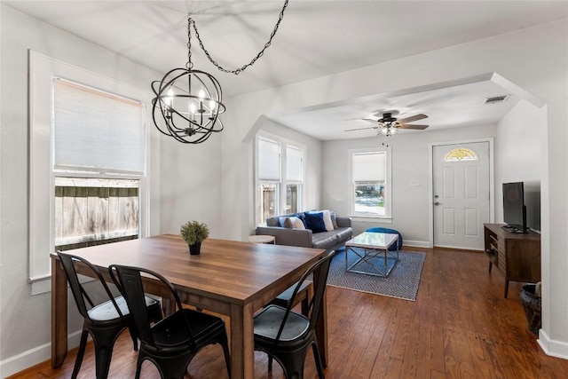 1208 Cedar Ave, Austin, TX 78702 - dining room featuring a chandelier, dark wood-style floors, ceiling fan, and arched walkways