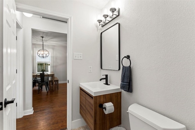 1208 Cedar Ave, Austin, TX 78702 - bathroom with wood finished floors, a chandelier, and vanity