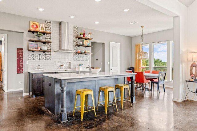 8054 Stone Mountain Trl, San Marcos, TX 78666 - kitchen featuring wall chimney range hood, open shelves, concrete flooring, backsplash, and light countertops