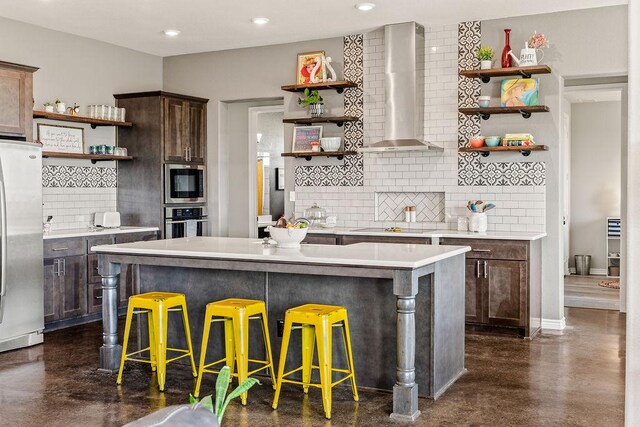 8054 Stone Mountain Trl, San Marcos, TX 78666 - kitchen featuring open shelves, wall chimney exhaust hood, appliances with stainless steel finishes, concrete floors, and recessed lighting