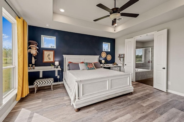 8054 Stone Mountain Trl, San Marcos, TX 78666 - bedroom featuring wood finished floors, a raised ceiling, ensuite bath, recessed lighting, and a ceiling fan