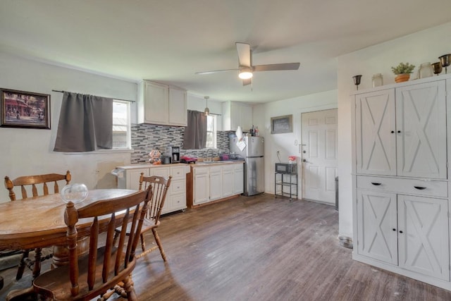 105 San Jacinto St, Smithville, TX 78957 - kitchen featuring freestanding refrigerator, a ceiling fan, wood finished floors, tasteful backsplash, and light countertops