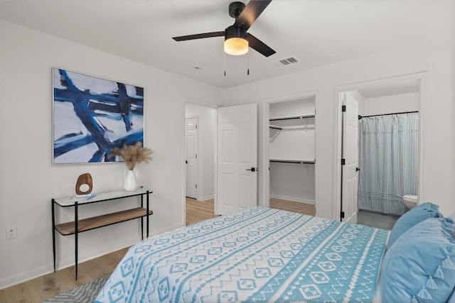 6516 Garden View Dr, Austin, TX 78724 - bedroom featuring wood finished floors, connected bathroom, a spacious closet, and a ceiling fan