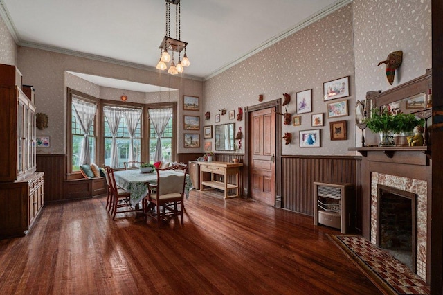 124 N Hamilton St, Gonzales, TX 78629 - dining space featuring a wainscoted wall, wallpapered walls, dark wood-style flooring, heating unit, and a high end fireplace