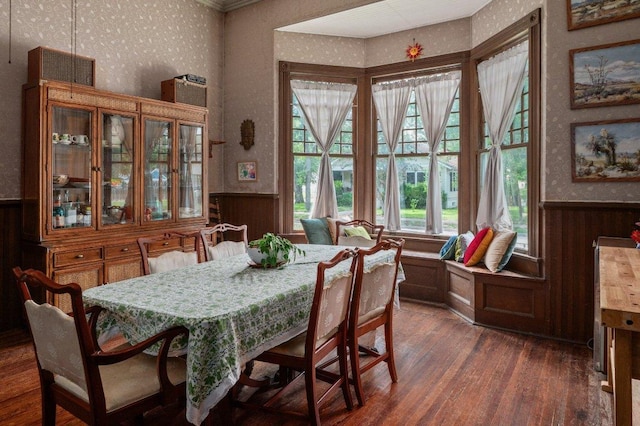 124 N Hamilton St, Gonzales, TX 78629 - dining room featuring wallpapered walls, wainscoting, dark wood-style floors, and wooden walls