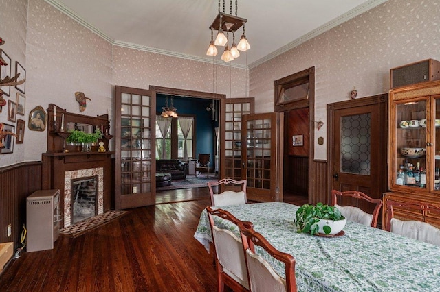 124 N Hamilton St, Gonzales, TX 78629 - dining area with french doors, a wainscoted wall, wood finished floors, wallpapered walls, and a premium fireplace