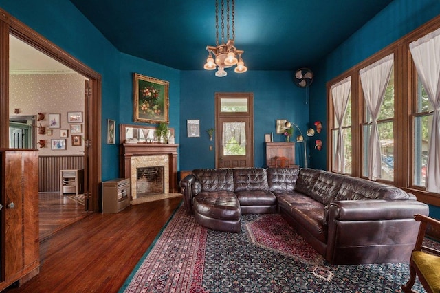 124 N Hamilton St, Gonzales, TX 78629 - living room with wood finished floors, a chandelier, a fireplace with flush hearth, and a wainscoted wall