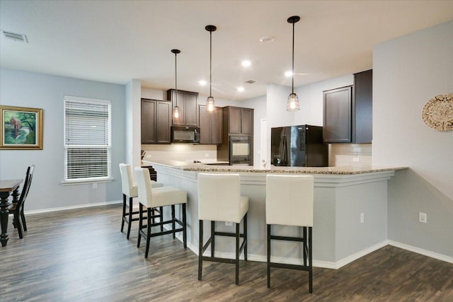806 Thrasher Glade Dr, Pflugerville, TX 78660 - kitchen with black appliances, backsplash, dark brown cabinets, dark wood-style flooring, and recessed lighting