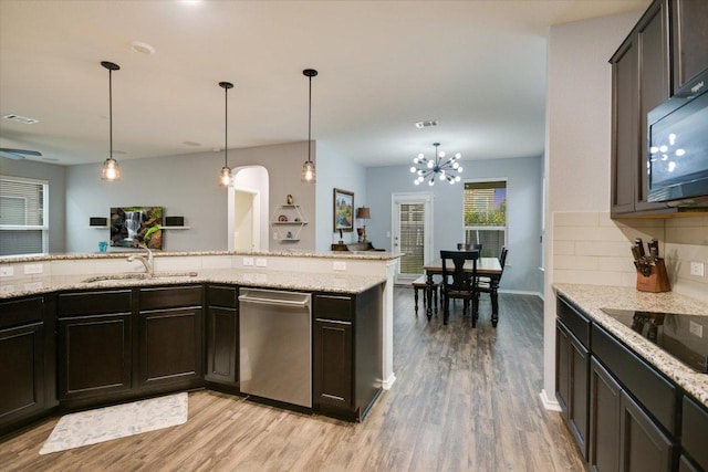 806 Thrasher Glade Dr, Pflugerville, TX 78660 - kitchen with black appliances, light wood-type flooring, decorative backsplash, and decorative light fixtures