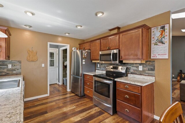 213 Circle C Ave, Fort Davis, TX 79734 - kitchen featuring stainless steel appliances, decorative backsplash, dark wood finished floors, and brown cabinetry