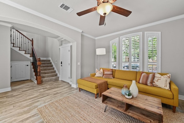 4024 Camacho St, Austin, TX 78723 - living room with stairway, light wood-style floors, ornamental molding, ceiling fan, and arched walkways