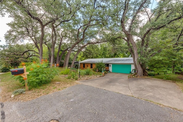 107 W Caddo St, Austin, TX 78753 - view of front of property with driveway, a metal roof, and an attached garage