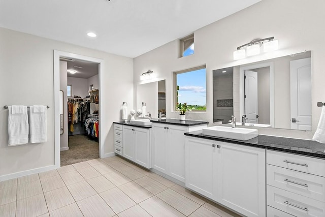 179 Sandy Creek Cv, Driftwood, TX 78619 - bathroom featuring vanity, a walk in closet, recessed lighting, tile patterned flooring, and a tile shower