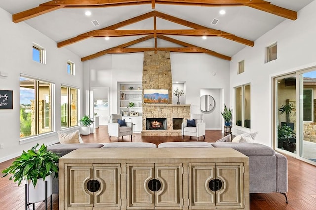 179 Sandy Creek Cv, Driftwood, TX 78619 - living room featuring high vaulted ceiling, wood finished floors, beamed ceiling, a fireplace, and healthy amount of natural light