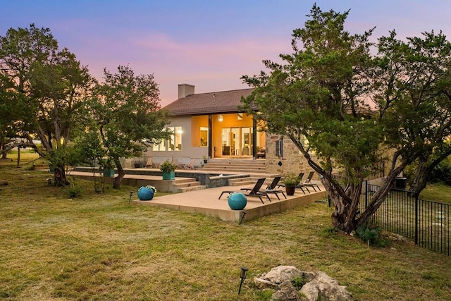 179 Sandy Creek Cv, Driftwood, TX 78619 - back of house at dusk with a patio and a chimney